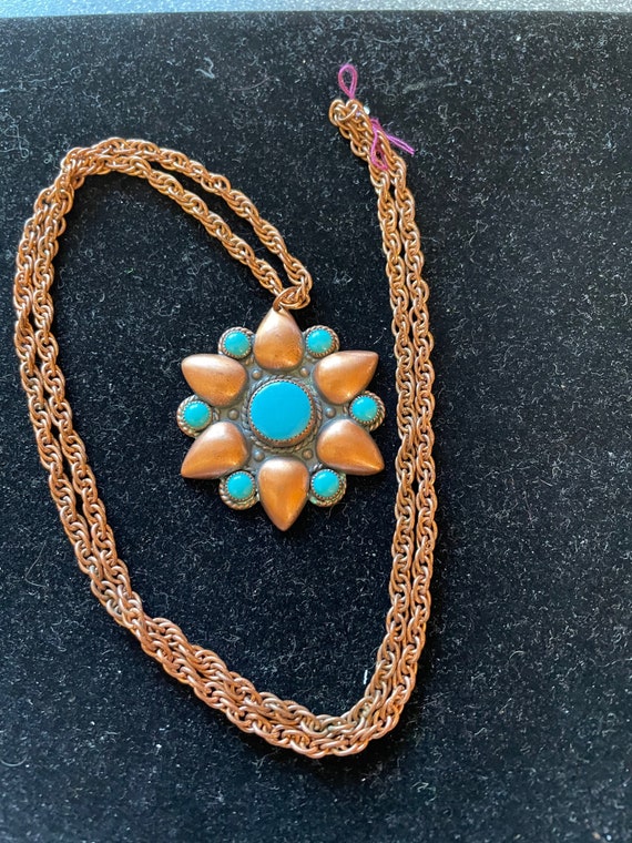 A solid copper chain with a copper flower which is