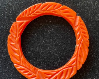 A KJL orange incised plastic flat bangle bracelet