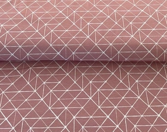 Op de afbeelding: Roze stof met een wit geometrisch patroon van overlappende driehoeken en vierkanten.