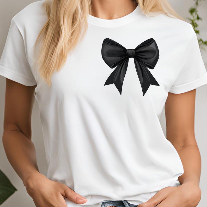 May include: A white t-shirt with a large black bow on the front.