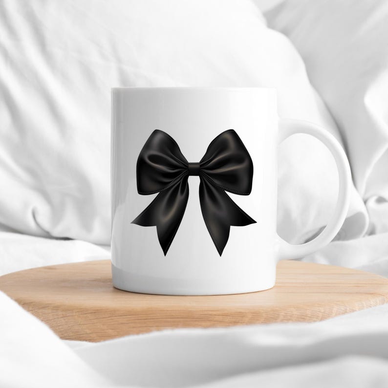 May include: White ceramic mug featuring a black satin bow design.