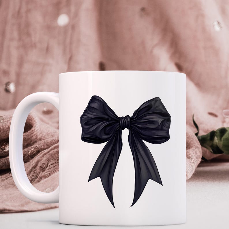 May include: White ceramic mug featuring a black bow illustration. The bow is tied with a knot in the centre and the ends of the bow are flowing down.