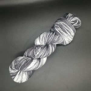 May include: A skein of black and white yarn with a variegated pattern.