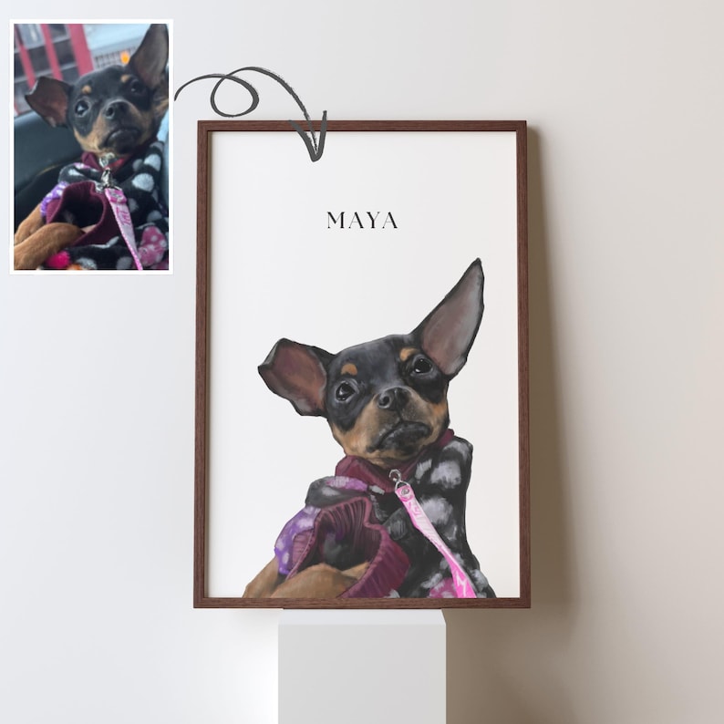 May include: A framed illustration of a black and brown dog with large ears. The dog is wearing a purple and white patterned sweater and a pink leash. The name "MAYA" is written in black text at the top of the illustration.