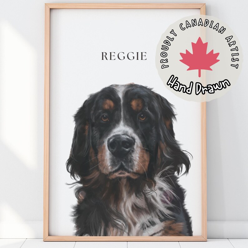May include: A hand-drawn illustration of a black, brown, and white dog named Reggie. The illustration is framed in a light wood frame and features a red maple leaf and the text "Proudly Canadian Artist, Hand Drawn".