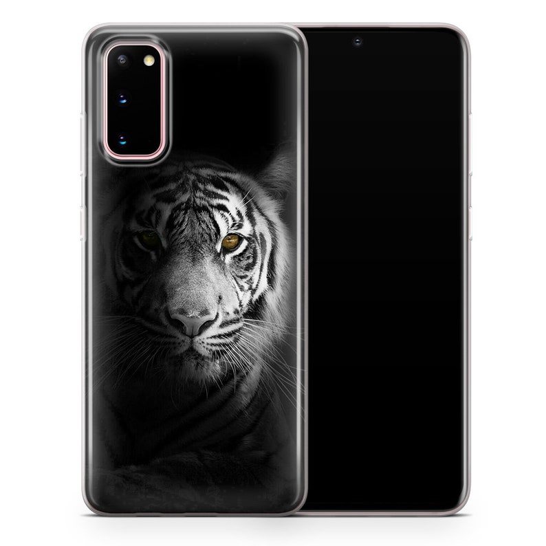 May include: A clear phone case with a black and white image of a white tiger with yellow eyes. The tiger is looking directly at the camera.