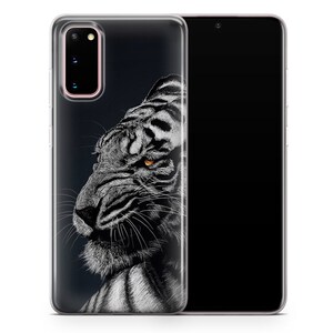May include: A clear phone case with a black and white illustration of a tiger's face. The tiger has a fierce expression and one orange eye.