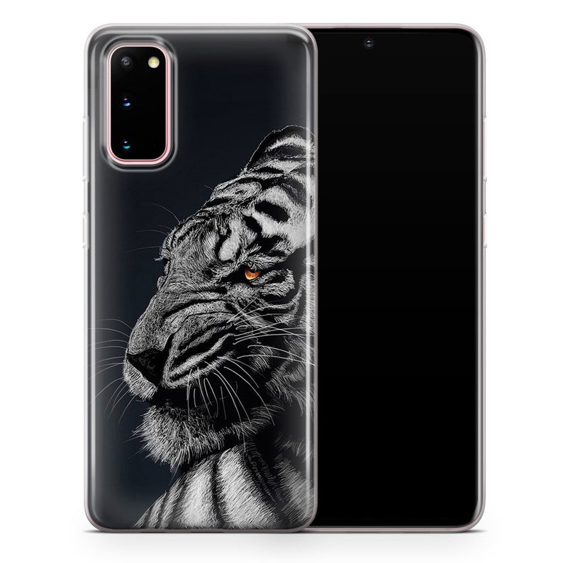 May include: A clear phone case with a black and white illustration of a tiger's face. The tiger has a fierce expression and one orange eye.