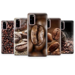 May include: Set of five phone cases featuring different coffee bean designs. The cases are clear and show the phone's color through the design. One case features a close-up of a single coffee bean, another shows a pile of coffee beans, and the others feature coffee beans scattered on a brown background.