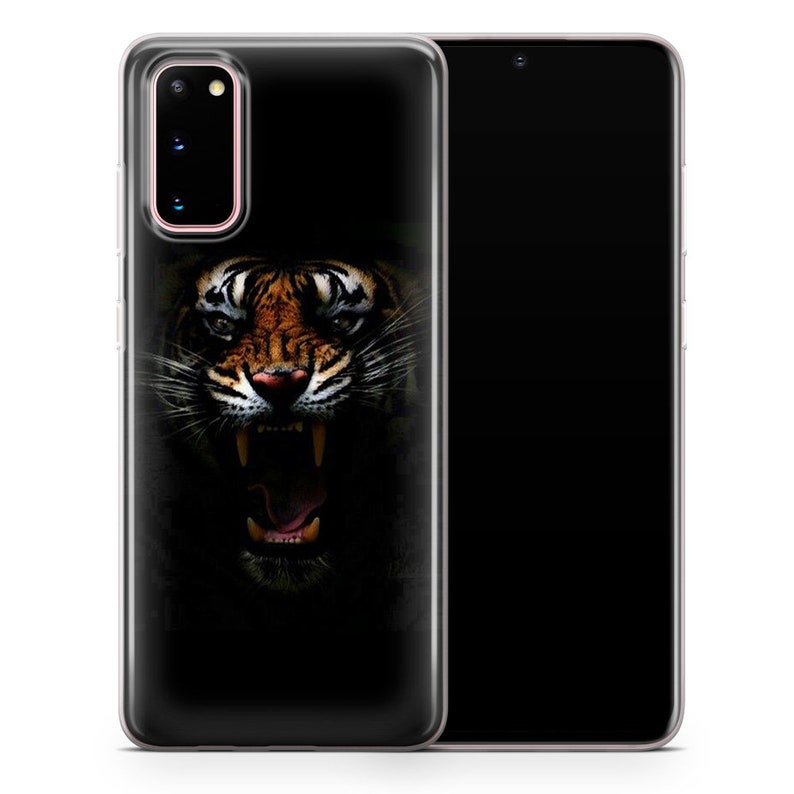 May include: A clear phone case with a black background and a close-up image of a tiger's face with an open mouth and sharp teeth. The tiger's fur is orange and black.