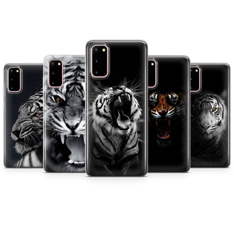 May include: Five phone cases with different images of tigers. The cases are clear and show the phone's color through the case. The tiger images are in black and white, except for one which is orange and black.
