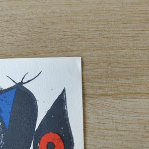 May include: A black and white abstract art print with a blue triangle and a red circle. The print is on a white background.