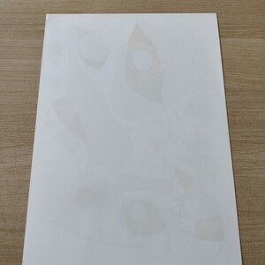 May include: A white sheet of paper with several faint, light brown, abstract shapes printed on it.