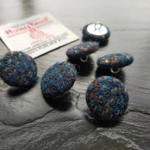 May include: Six blue, brown and white tweed fabric buttons with silver metal shanks.