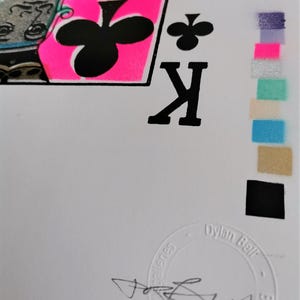 K&ouml;nnte beinhalten: Eine schwarz-wei&szlig;e Spielkarte mit dem K&ouml;nig der Kreuz auf rosa Hintergrund. Die Karte ist von Dylan Bell signiert.