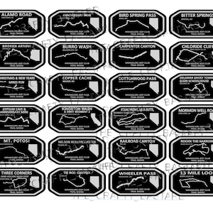 May include: A collection of 20 black and white stickers featuring different off-road trails in Nevada. Each sticker has a white outline of the state of Nevada with a trail route marked in white. The text "Wranglers Jeep Club Trail Badge" appears on each sticker.