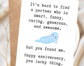 May include: A white greeting card with black text that reads: It's hard to find a partner who is smart, funny, caring, generous, and awesome. But you found me. Happy anniversary, you lucky thing. A light blue cartoon character is lying down.