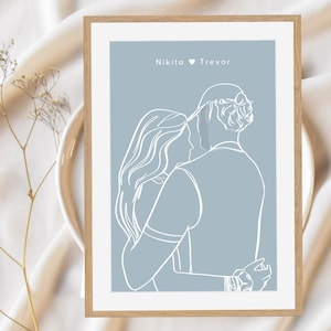 May include: A minimalist line art print of a couple embracing, with the names Nikita and Trevor and a heart symbol above them. The print is on a light blue background.