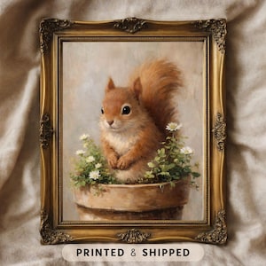 Könnte beinhalten: Gerahmter Kunstdruck mit einem Gemälde eines Eichhörnchens. Das rotbraune Eichhörnchen sitzt in einem Blumentopf mit weißen Blüten. Der verzierte goldene Rahmen verleiht dem Kunstwerk einen Vintage-Look.