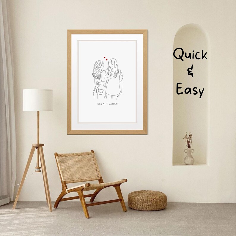 May include: A framed line drawing of two women standing back to back with their arms around each other. The drawing is in black and white with red hearts above the women's heads. The text "Ella - Sarah" is below the drawing.