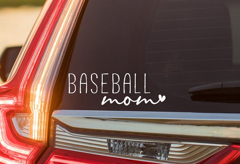 May include: White vinyl decal with the text "BASEBALL mom" and a small heart on a black car window.