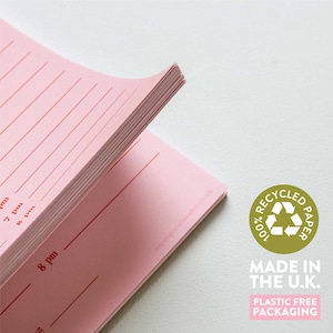 May include: Pink notebook with red lines and text, 7 pm, 8 pm, and 8 am. The notebook is made from 100% recycled paper and has plastic-free packaging. The text "onceuponatuesday.co.uk" is printed on the cover.