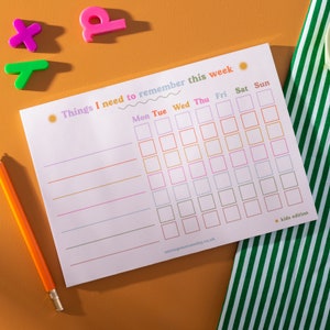 May include: A printable weekly planner with a colorful design. The planner has a title that says "Things I need to remember this week." The planner has a grid with days of the week labeled at the top: Monday, Tuesday, Wednesday, Thursday, Friday, Saturday, and Sunday. The planner has a note at the bottom that says "kids edition".