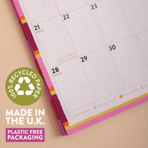 May include: A wall calendar page with a grid showing dates 21 through 30, including the text Summer Solstice (N. Hemisphere). A green circular badge reads 100% RECYCLED PAPER, MADE IN THE U.K., and PLASTIC FREE PACKAGING. The edges feature pink and orange stripes.