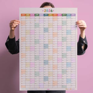 Op de afbeelding: Een grote, kleurrijke wandkalender voor het jaar 2026. Elke maand wordt weergegeven in een apart vak met een andere pastelkleur. De kalender is perfect om je jaar te plannen en te organiseren.