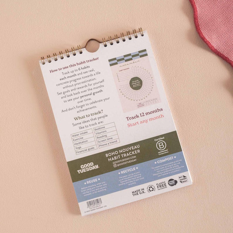 May include: A spiral-bound habit tracker with a white background and text. The tracker includes instructions, a circular chart, and a list of habits to track. The words "BOHO NOUVEAU HABIT TRACKER" are visible.