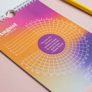 May include: A pink and orange habit tracker for the month of August. The tracker has a circular grid with numbers 1 through 31 around the edge. The quote "The man who removes a mountain begins by carrying away small stones. - Chinese Proverb" is printed in the centre of the grid.