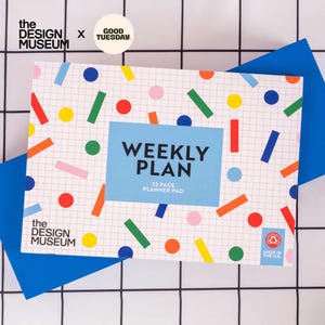 May include: A rectangular weekly planner pad featuring a white grid background with colorful geometric shapes in red, blue, green, yellow, and pink. The center has a light blue rectangle with the text WEEKLY PLAN 52 PAGE PLANNER PAD.