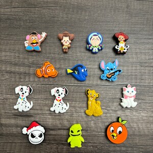 May include: A collection of 15 colorful cartoon character charms, including characters from Toy Story, Finding Nemo, Lilo & Stitch, 101 Dalmatians, The Lion King, and The Nightmare Before Christmas. The charms are made of a soft, rubbery material and are perfect for adding a touch of Disney magic to your belongings.