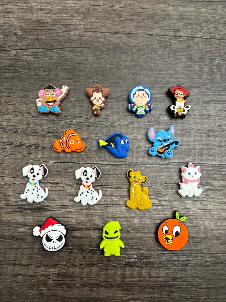 May include: A collection of 15 colorful cartoon character charms, including characters from Toy Story, Finding Nemo, Lilo & Stitch, 101 Dalmatians, The Lion King, and The Nightmare Before Christmas. The charms are made of a soft, rubbery material and are perfect for adding a touch of Disney magic to your belongings.