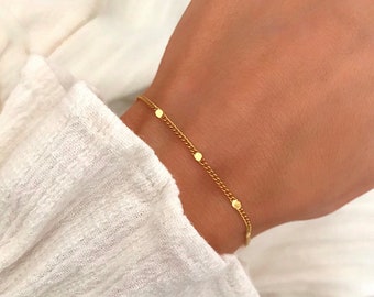 Vergulde armband met kleine, fonkelende details en een dunne vergulde ketting.