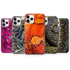 Könnte beinhalten: Fünf verschiedene iPhone-Hüllen mit Schlangenhautmustern. Die Hüllen sind transparent und zeigen das Objektiv der Telefonkamera. Die Muster umfassen eine rosa und violette Schlangenhaut, eine braune und schwarze Schlangenhaut, eine rote und orangefarbene Schlangenhaut, eine grüne und schwarze Schlangenhaut sowie eine braune und beigefarbene Schlangenhaut.