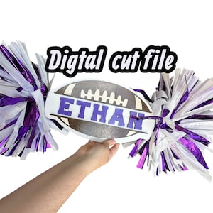 May include: A wooden football-shaped sign with the name "ETHAN" in purple letters. The sign is flanked by purple, white, and silver pom-poms. The text "Digital cut file" is above the sign.