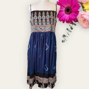 May include: A blue and black sleeveless dress with a paisley print and a gathered skirt.