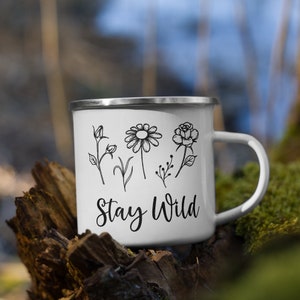 May include: White enamel camping mug with a black outline of flowers and the text "Stay Wild".