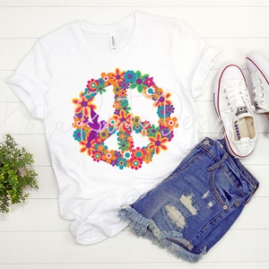 May include: White t-shirt with a peace sign made of colorful flowers. The peace sign is in the center of the shirt.