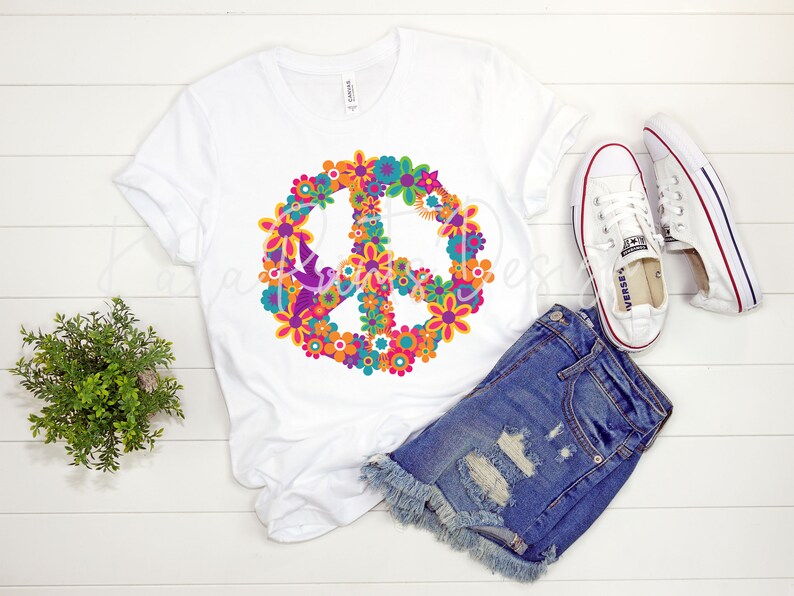 May include: White t-shirt with a peace sign made of colorful flowers. The peace sign is in the center of the shirt.