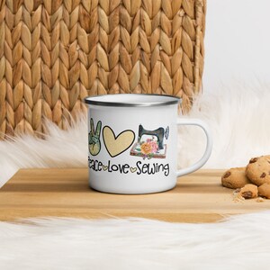 May include: White enamel mug featuring a peace sign, heart, and sewing machine graphic. The text "Peace Love Sewing" is printed on the mug.