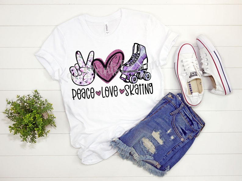 Może przedstawiać: Biała koszulka z symbolem pokoju, sercem i grafiką rolek. Pod grafiką nadrukowany jest tekst "peace love skating".