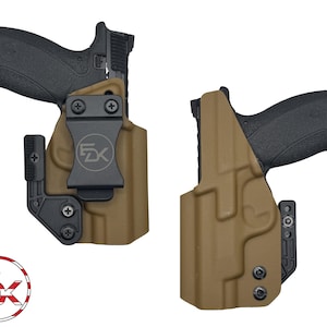 May include: Two tan-colored gun holsters with black hardware. One holster has a black handgun inserted. The holsters have a clip for attaching to a belt. The logo "FZK" is visible on the clip. The holsters are designed to securely hold a firearm.