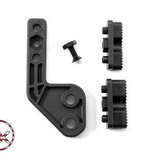 Puede incluir: Un soporte de pl&aacute;stico negro en forma de L con tres agujeros y una superficie texturizada. Dos bloques de pl&aacute;stico negro con superficies texturizadas y tres agujeros cada uno. Un tornillo de metal negro con cabeza hexagonal.