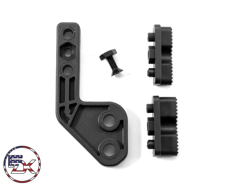 Puede incluir: Un soporte de pl&aacute;stico negro en forma de L con tres agujeros y una superficie texturizada. Dos bloques de pl&aacute;stico negro con superficies texturizadas y tres agujeros cada uno. Un tornillo de metal negro con cabeza hexagonal.