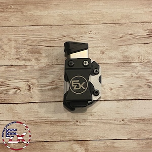 May include: Black and white cow print magazine holder with a black clip and a gold "FDX" logo.