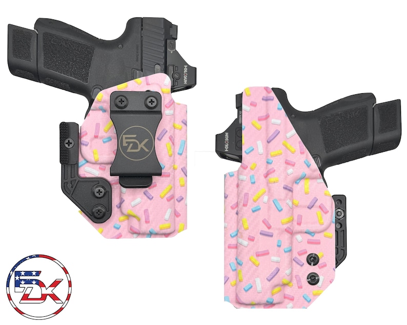 May include: Two pink and white patterned holsters for concealed carry of a handgun. The holsters have a black clip and a black trigger guard. The pattern is reminiscent of sprinkles on a pink cake.
