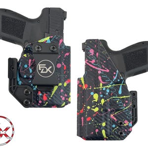May include: Two black Canik handguns inside molded holsters featuring a black carbon fiber texture with a vibrant neon paint splatter pattern in pink, yellow, and blue. Each holster includes a black belt clip with the FDK logo and black screws.
