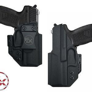 May include: Two black holsters for a handgun, with a black gun in one of the holsters. The holsters have a clip on the back and a button on the side. The holsters are made of a textured material.